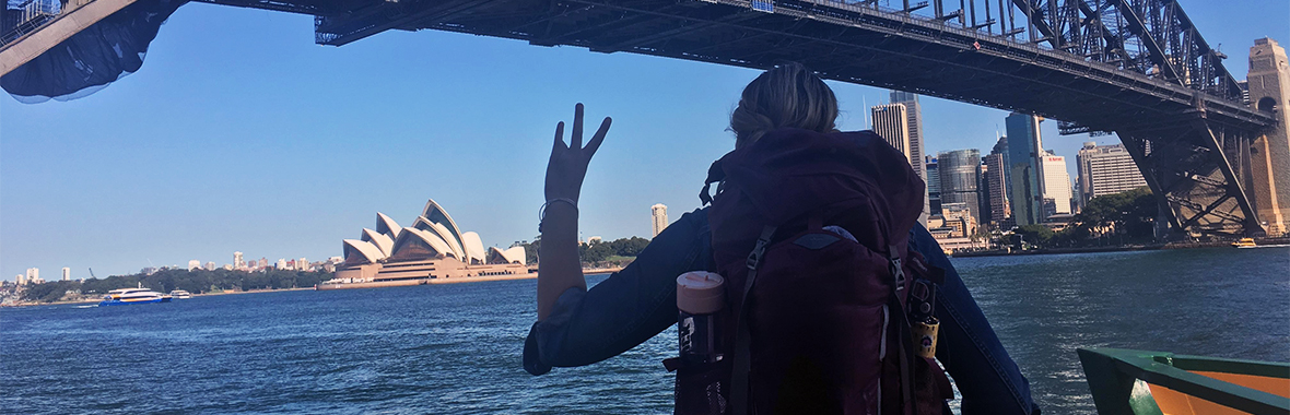 Person giving the forks up under a bridge