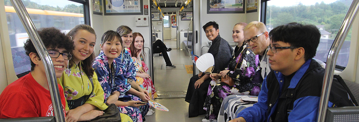 People smiling for a picture while sitting on a train