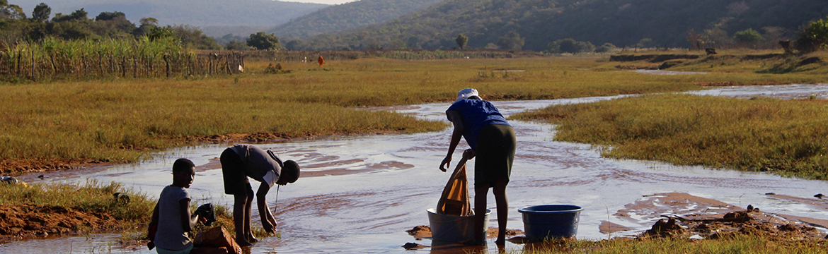People washing their clothes in a body of water