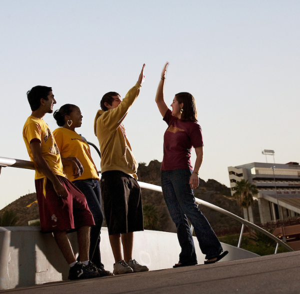 student high fiving on bridge